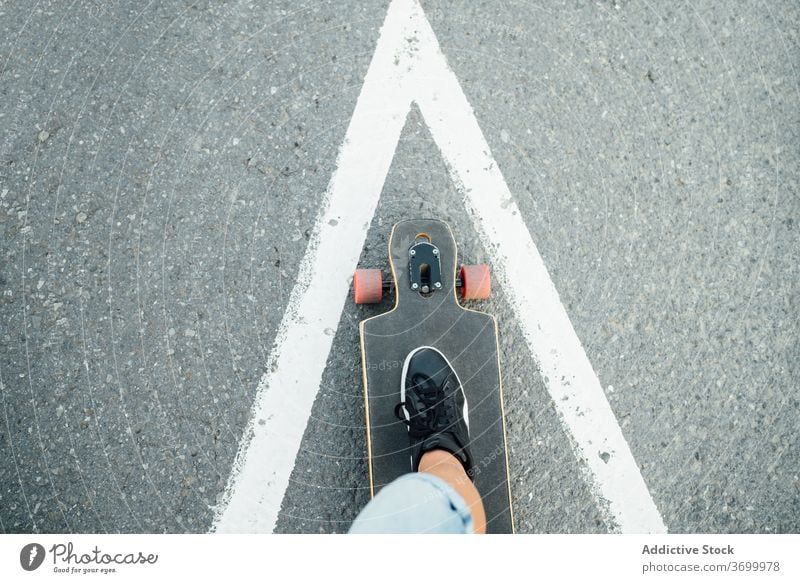 Crop skater on longboard on street ride man hobby extreme urban relax cool male summer young hipster stand modern town contemporary style street style guy