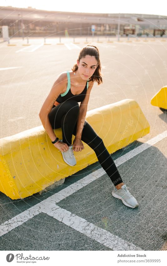 Sporty woman tying laces on sneakers before training sportswoman tie shoelace prepare runner sporty street fit athlete active young rest lifestyle break fitness