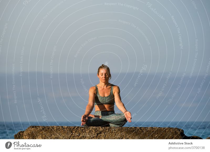 Calm woman doing yoga in Lotus pose lotus pose meditate tranquil mindfulness sea sunset mudra peaceful sundown gesture serene twilight calm harmony zen asana