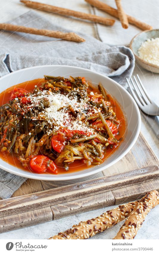 Sauteed green cicory and tomatoes topped with caccioricotta cheese Healthy stir top view copy space dark fork plate napkin Vitamins Cooked Mediterranean