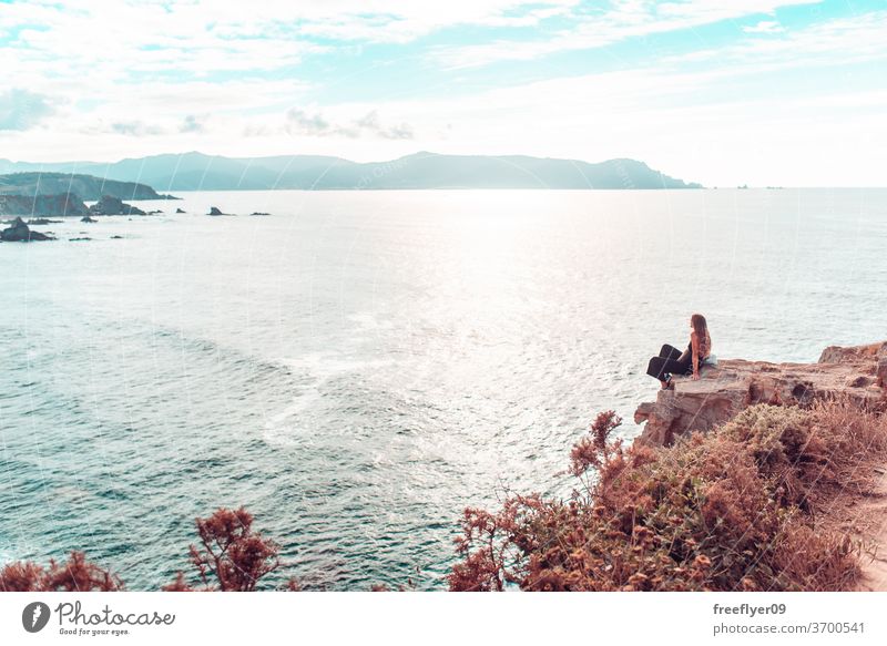 Woman contemplating the ocean from a cliff woman hiking copy space landscape seascape loiba galicia cliffs rocks rocky atlantic tourism spain horizon clean