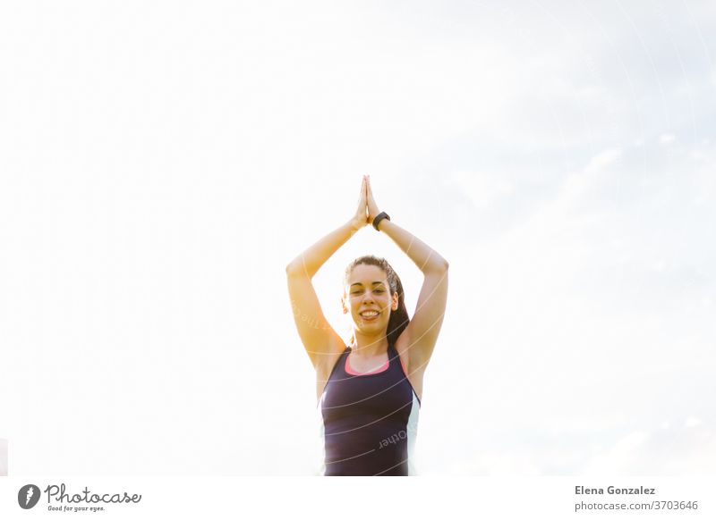 Happy young brunette female exercising and stretching in the park fit yoga woman fitness exercise meditation sports balance pose relaxation workout