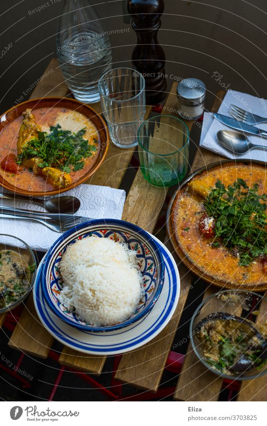 Set table on the balcony with delicious Indian curry and rice laid table Curry powder Rice oriental Balcony out Eating Nutrition Living or residing Table