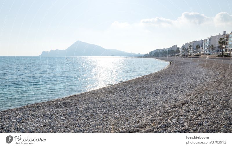 Stone beach with view on sunny Altea coastline and mountains, Costa Blanca, Spain altea ocean spain sky sea landscape vacation nature tourism sunset blue