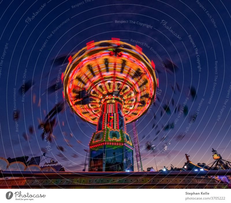 Chain carousel ride at evening hour from lower perspective. entertainment fun teens people attraction teenager blur chain chain caroussel folks leisure festival