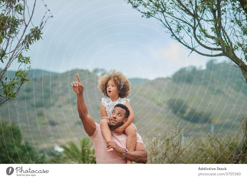 Ethnic father and daughter exploring nature explore together summer mixed race curious kid point parent dad child ethnic love lifestyle relationship observe