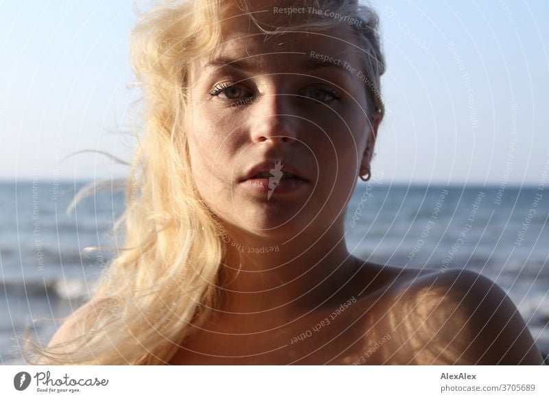 Portrait of a young blonde woman in front of the Baltic Sea Young woman Woman girl 18-20 years Blonde Slim already Curly sensual natural green eyes long hairs