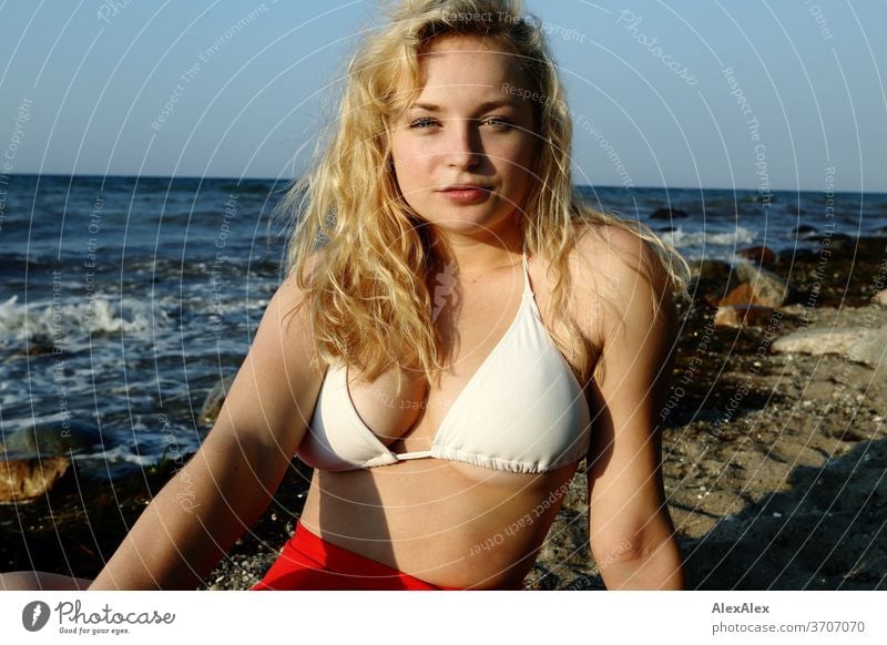 Portrait of a young blonde woman in front of the Baltic Sea Young woman Woman girl 18-20 years Blonde Slim already Curly sensual natural green eyes long hairs