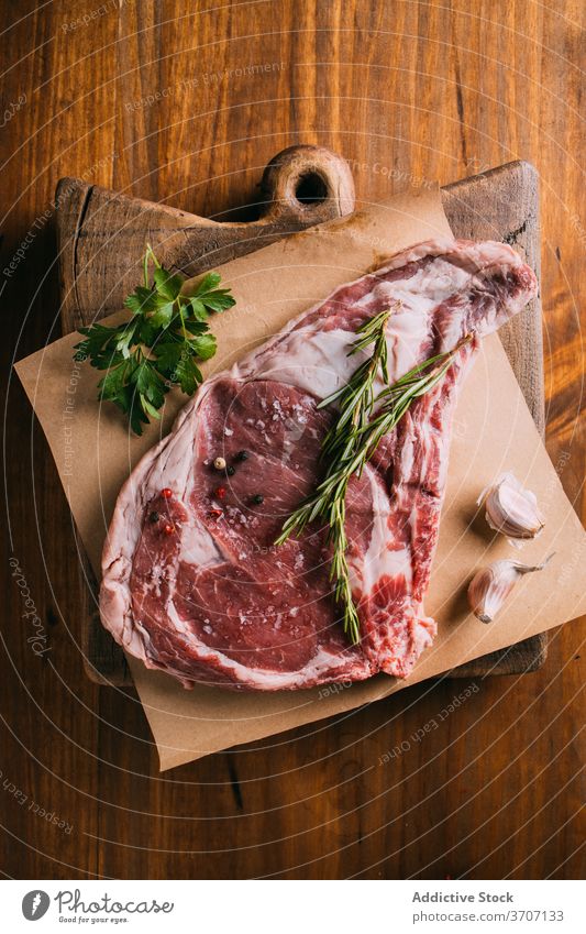 Raw meat on table with various ingredients raw beef condiment seasoning vegetable arrangement kitchen piece craft paper fresh olive oil leaves garlic culinary