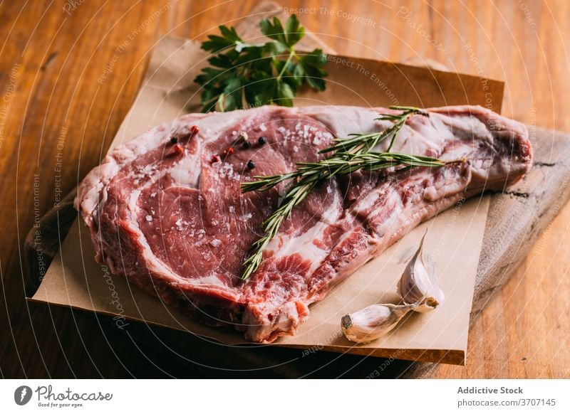 Raw meat on table with various ingredients raw beef condiment seasoning vegetable arrangement kitchen piece craft paper fresh olive oil leaves garlic culinary