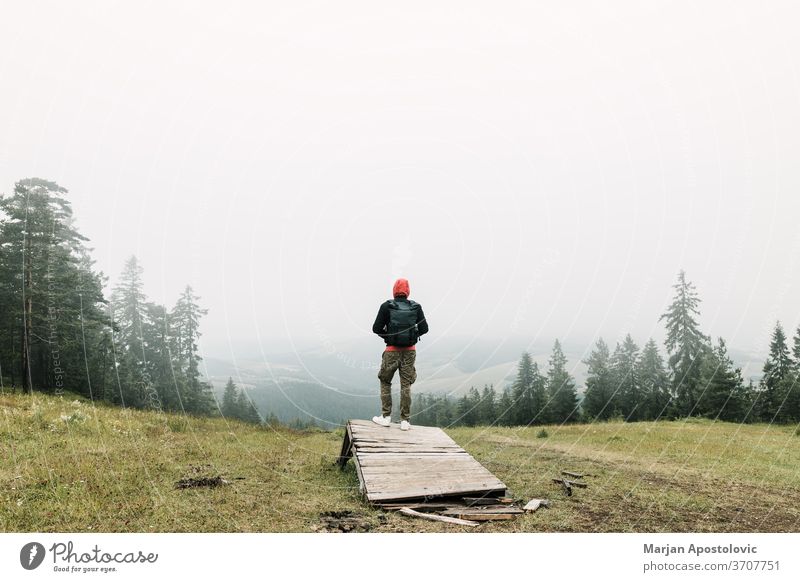 Nature explorer enjoying the view of  a foggy mountain range adventure alone backpack backpacker environment exploring forest freedom green hike hiker hiking