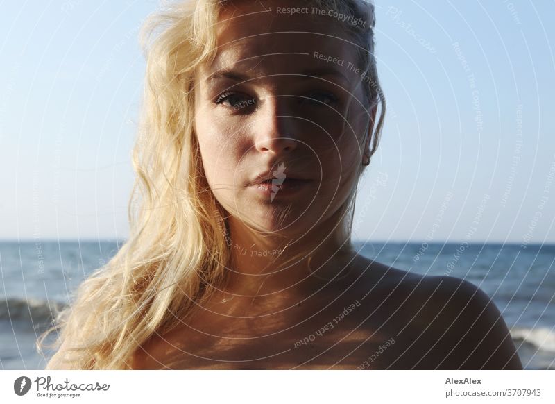 Portrait of a young blonde woman in front of the Baltic Sea Young woman Woman girl 18-20 years Blonde Slim already Curly sensual natural green eyes long hairs