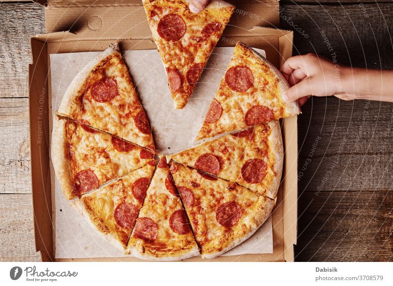 Two hands takes slices of pizza from cardboard box, top view food junk menu background pepperoni cheese table italian sharing cafe share family eating lunch