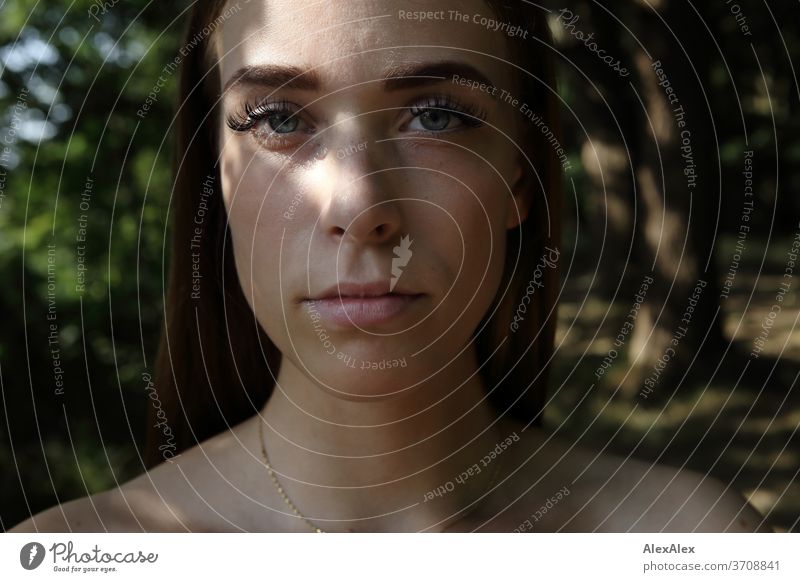 Close portrait of a young woman in the forest Light Athletic Feminine Emotions emotionally Looking into the camera Central perspective Shallow depth of field