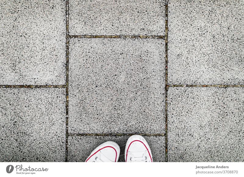 Walking on the sidewalk Street off walkway slabs Footpath Footwear foot Downward Asphalt Stand Woman Exterior shot Gray White Day Human being shape Pattern