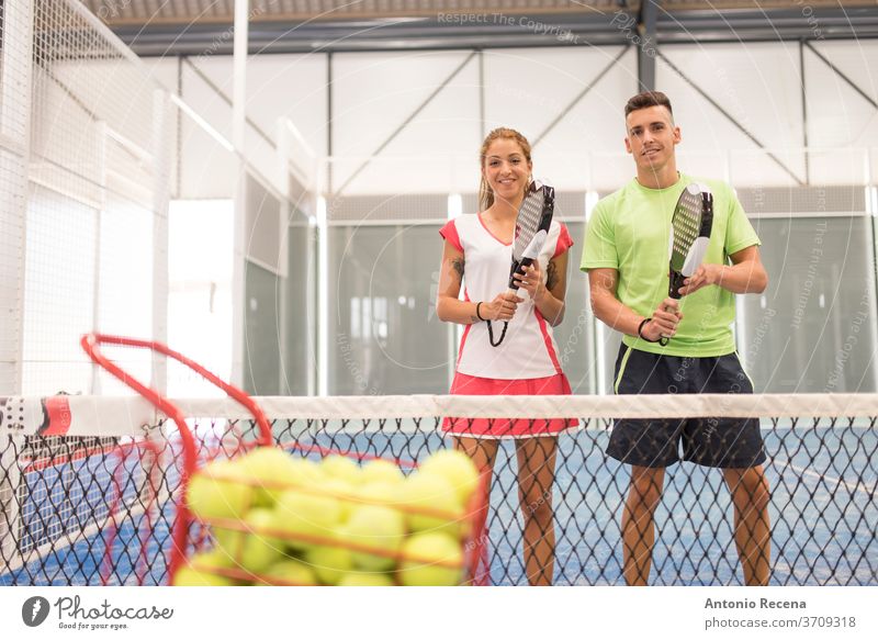 Couple playing paddle tennis in blue court padel pádel sport sports recreation class man woman women lifestyles training shot couple net ball leisura people