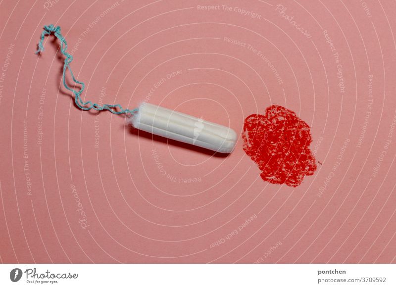 Tampon moving towards red painted spot. Menstruation, blood, period, menstrual flow. symbol picture Hemorrhage Reconnaissance symbolism Feminine Colour photo