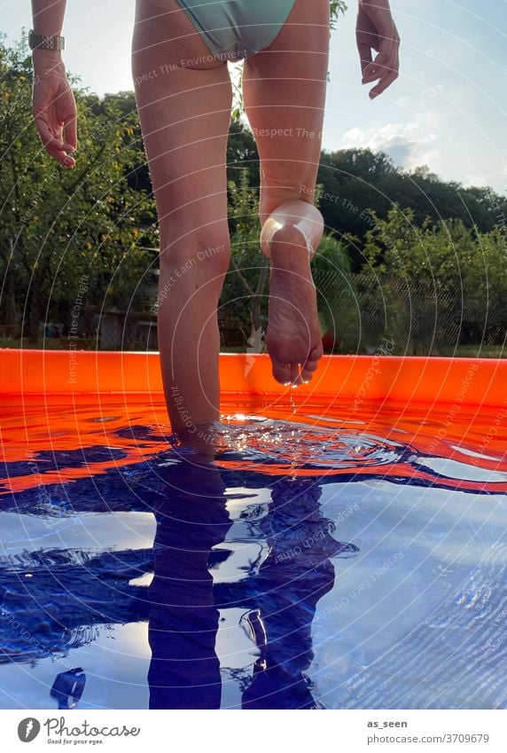 Refreshment in the garden pool Paddling pool Going Water foot Orange Blue green Bikini Exterior shot Summer Swimming & Bathing Wet Reflection at home Garden