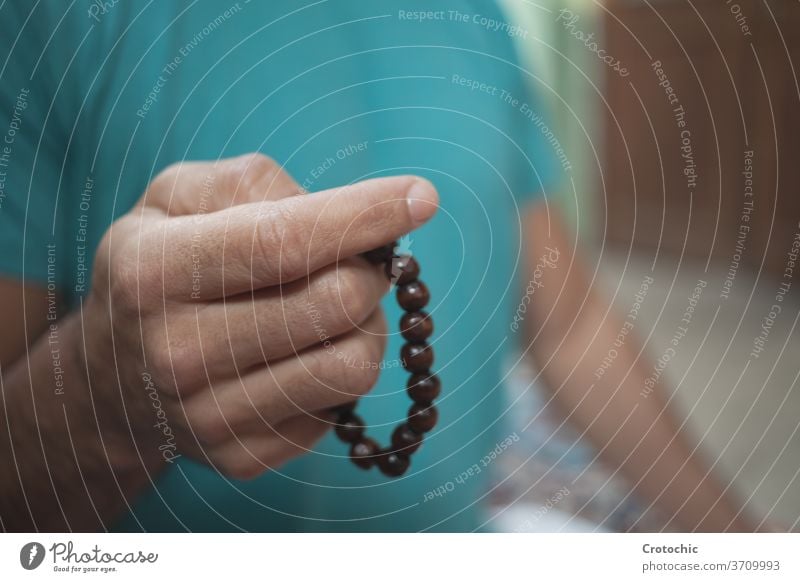 Selective focus on the hand of a man with a chakra wooden ball bracelet hold roll selective detail fortune festivity balance alternative jewell luck costume