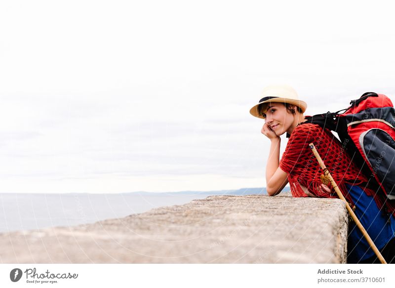 Excited travelling woman standing at seaside pilgrimage hike camino de santiago backpack point away amazed spain activity female excited discovery environment