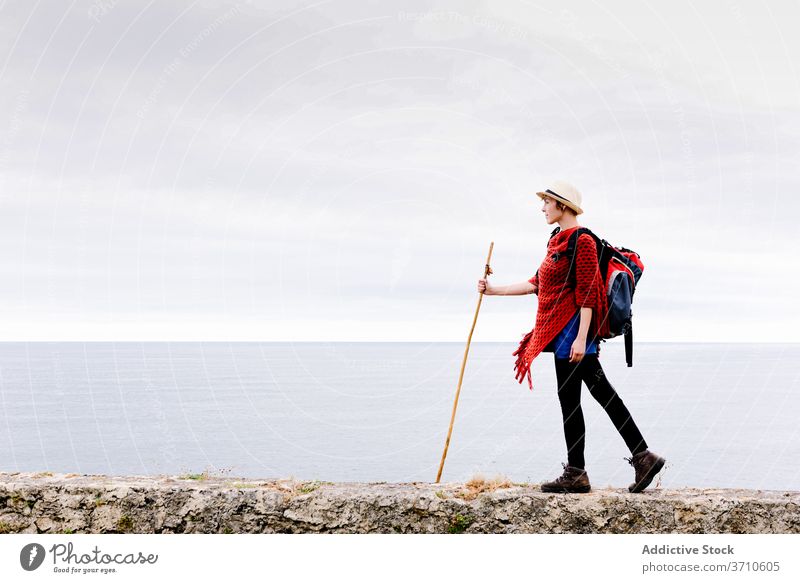 Happy traveler with trekking stick enjoying freedom hiker backpacker woman happy pilgrimage nature activity camino de santiago spain cliff female asturias