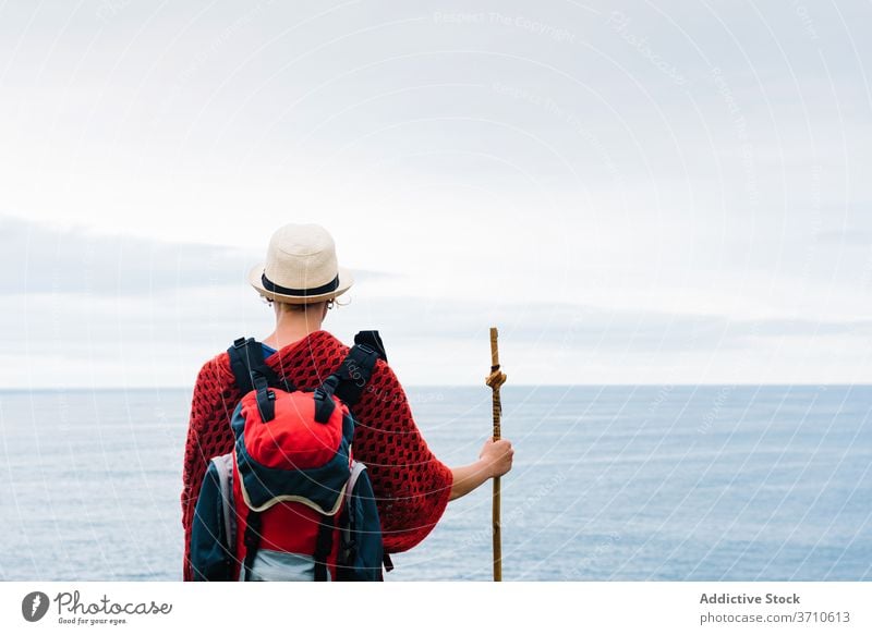 Anonymous traveler with trekking stick enjoying freedom hiker backpacker woman happy pilgrimage nature activity camino de santiago spain female asturias llanes