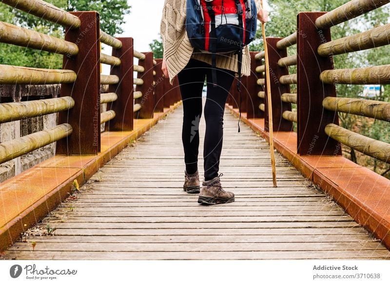 Hiker walking on wooden bridge hiker traveler pilgrimage way path stick backpacker trekking activity lonely camino de santiago spain asturias llanes lifestyle