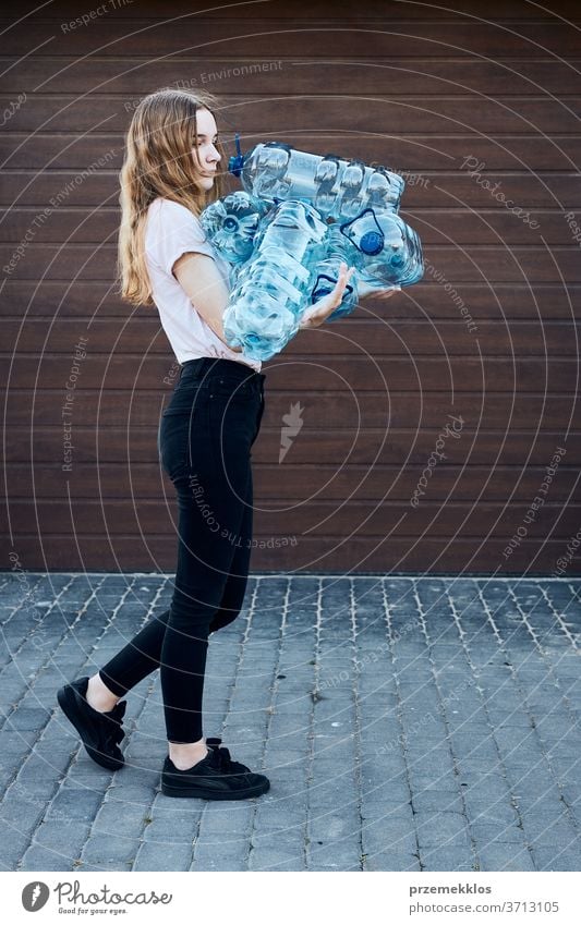 Young woman throwing out empty used plastic water bottles into trash bin. Collecting plastic waste to recycling. Concept of plastic pollution and too many plastic waste. Environmental issue