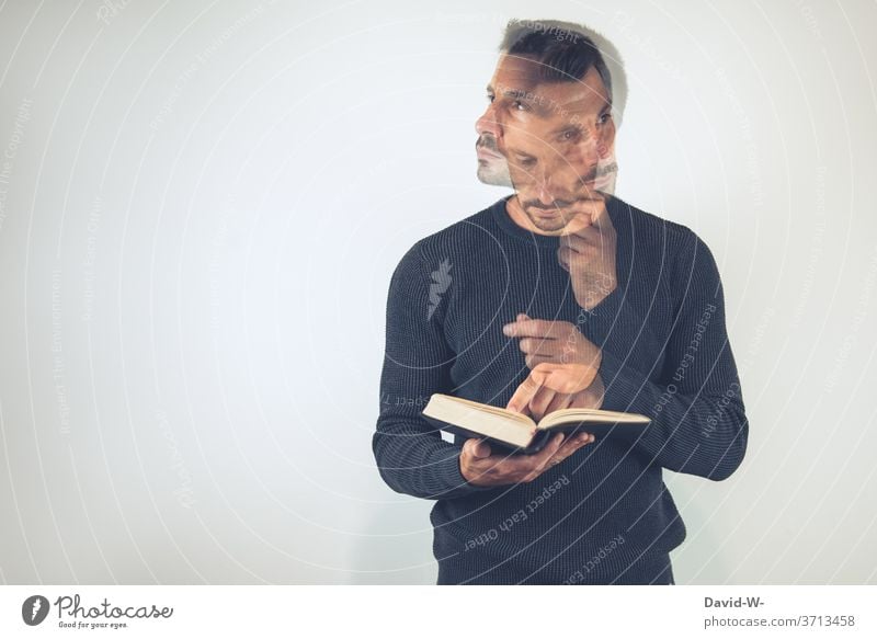 Man holds a book in his hands and looks up something / thinks / thinks Meditative Book books Reading Education Study Library Know School Literature