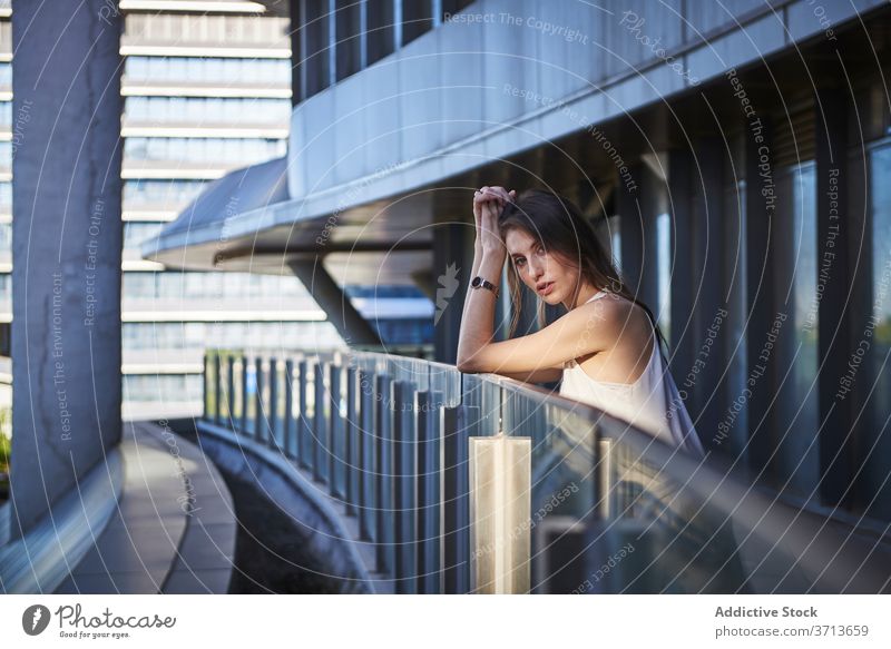 Thoughtful young woman standing near modern building thoughtful pensive lonely think urban sad female contemporary contemplate lifestyle dream alone serious