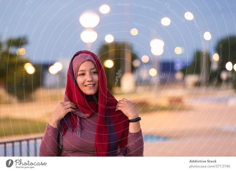 Smiling Arab woman in hijab on street put on muslim religious city evening headdress content female ethnic arab smile happy style glad delight joy relax