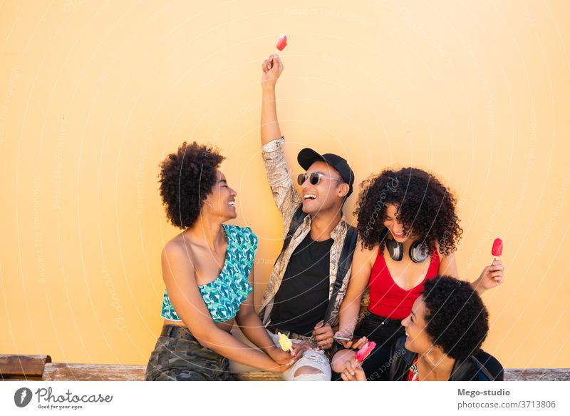 Multi-ethnic group of friends enjoying summertime while eating ice cream. multiethnic friendship young people dessert diversity diverse pleasure man woman