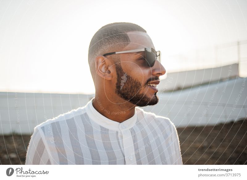 Portrait of a confident and casual man, modern muslim wearing sunglasses entrepreneur moroccan elegant lifestyle fashionable cool hope light success