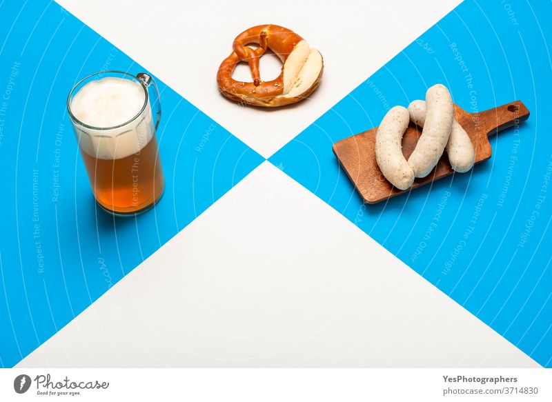 Oktoberfest table with a pint of beer, white sausage, and pretzel. Bavarian traditional meal Germany alcohol ale background bar bavarian beverage blue brew