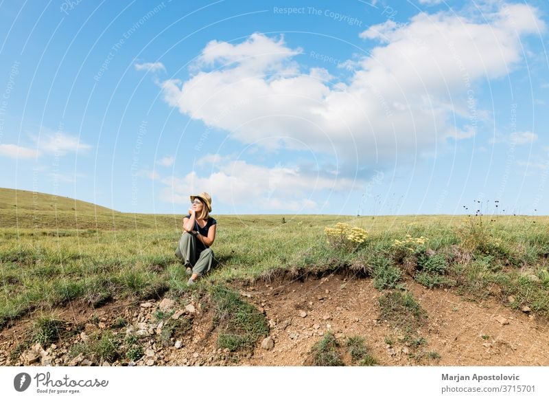 Young woman enjoying on the hillside meadows adult carefree casual caucasian cheerful countryside environment explore female field freedom grass green happiness