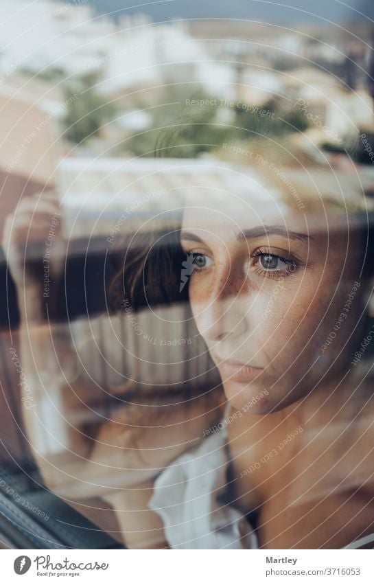 Portrait of a pretty brunette woman with blue eyes, looking out the window, photographed through the glass sexy lip portrait at home stay at home model bedroom