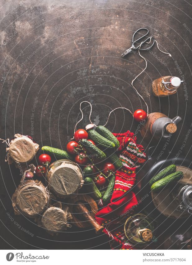 Preparation of homemade pickled cucumbers in jars . Rustic . Border preparation scissors cord red kitchen towel oil vegetables rustic autumn concept dark