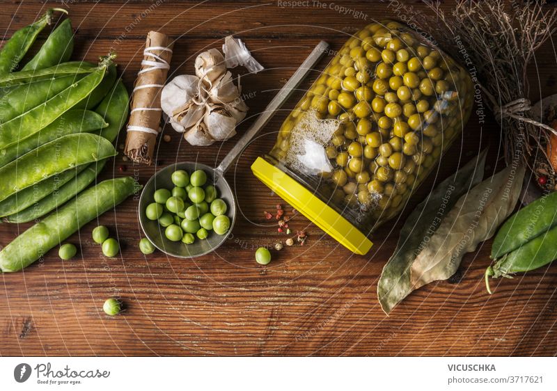 Preserving of garden vegetables. Green peas canning in jar on wooden background with ingredients. Top view. Homemade preserve concept green top view healthy