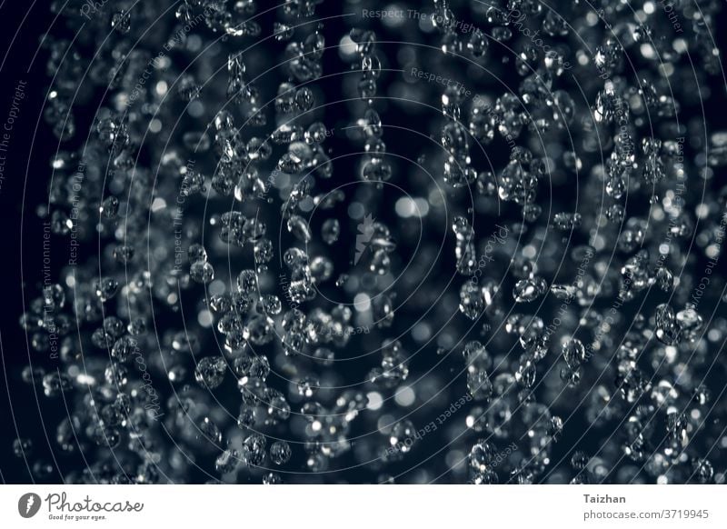 close up rain water drop falling to the floor. Dark mood style . Motion blur , soft focus abstract blue macro natural colours crown flow liquid purity