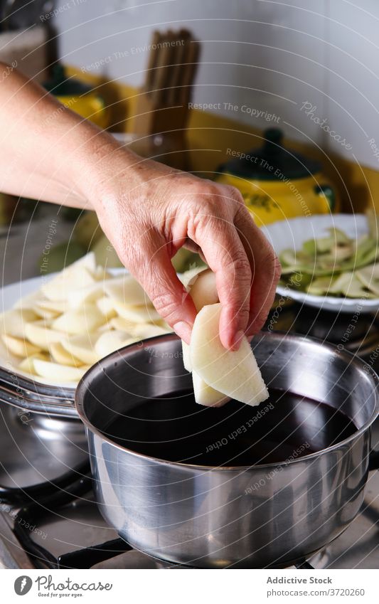 Crop woman cooking in kitchen prepare pear red wine homemade poached boil sweet female dessert saucepan delicious tasty alcohol ingredient meal slice fruit food