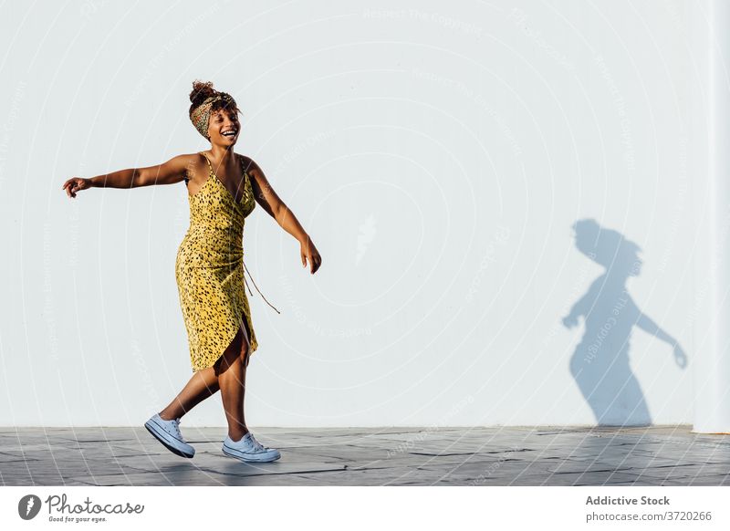 Carefree ethnic woman on street carefree turn around freedom delight having fun urban trendy style city female african american black summer optimist dance glad