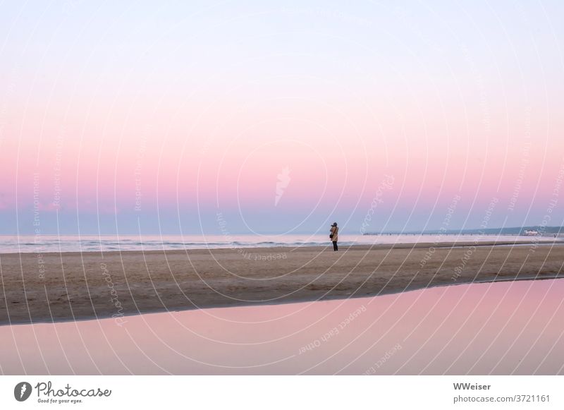 Photographer stands alone on the beach, romantic atmosphere prevails photo countess Beach Coast Sunset Pink pastel shades Smooth far silent Take a photo