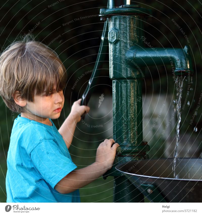 Quick march! - Boy pumps water with a handle pump Child Boy (child) Upper body Pump Water pump Old nostalgically Sunlight Evening sun Light Shadow Stand look