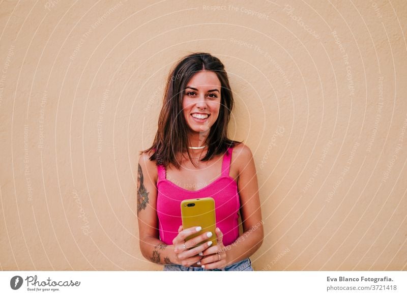 beautiful young woman outdoors taking a picture with mobile phone. Technology and lifestyle street urban smiling city technology tattoo modern happy summer