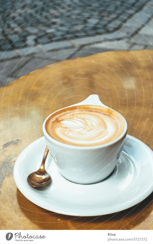 A cup of cappuccino on a golden table in the café Cappuccino Coffee Café Table latte type Cup Caffeine Beverage To have a coffee Coffee break Delicious warm