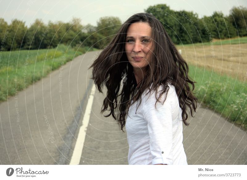 Woman with long flowing hair looks into the camera Hair and hairstyles Movement Street Lanes & trails Feminine smile Spirited Swing Good mood Spontaneous