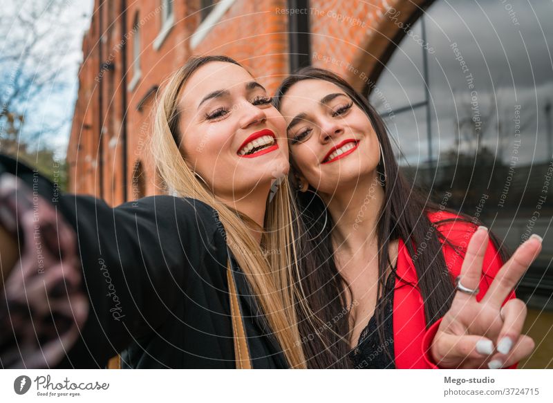 Two young friends taking a selfie outdoors. portrait two cheerful street adult hangout girls travel woman urban leisure joy style cool enjoyment positive