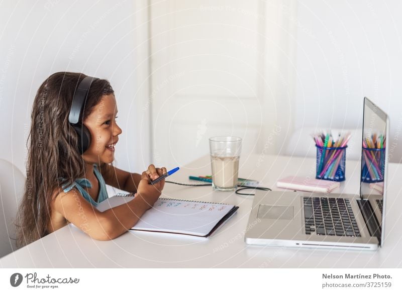 Little hispanic girl studying in front of the laptop. E-learning, study at home online. computer children young video school education e-learning technology