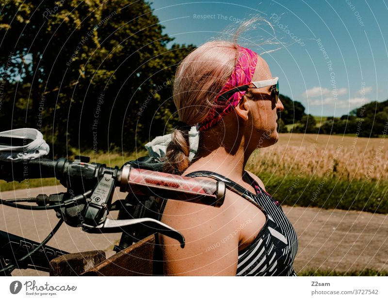 Young cyclist takes a break Cyclist mtb bike tour bicycle trip cycle path Danube Green trees Bushes Sky voyage Backpacking Exterior shot Nature Landscape