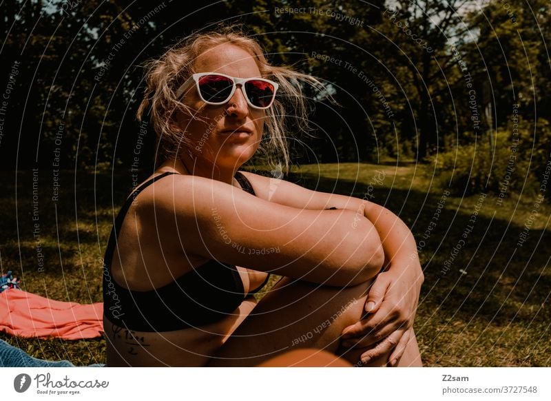 Young woman relaxing by the lake be afloat Lake Beach way sunbathe Summer Sun Bikini sunglasses Blonde Athletic Easygoing Cool teen youthful Swimming & Bathing